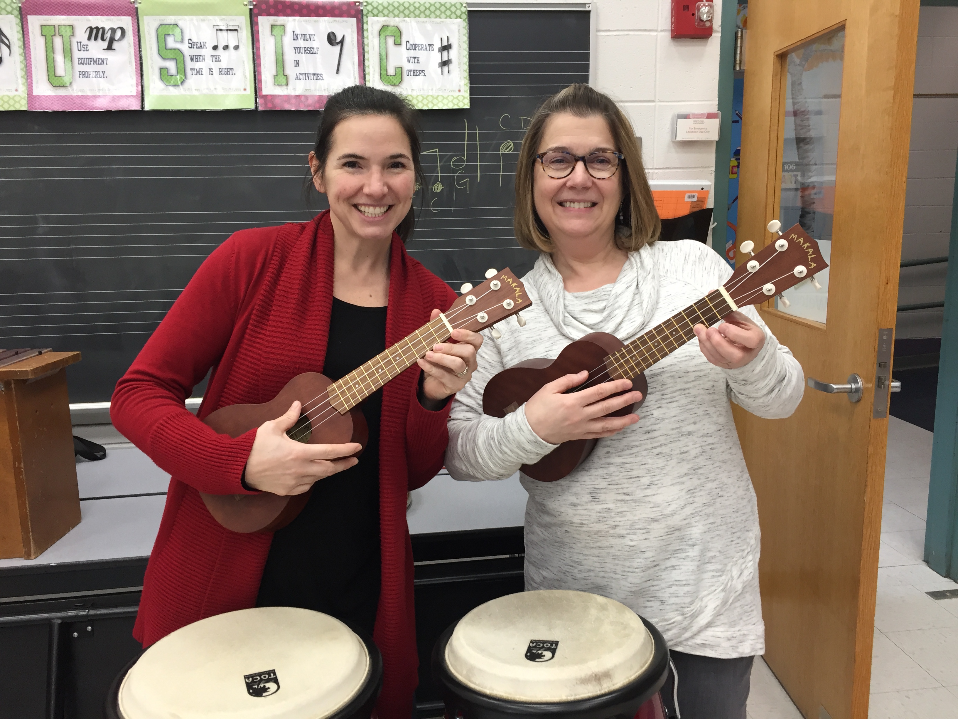 Shown are Holliston elementary school music teachers, Chrissy Petersen and Lori Anderson York, who will be teaching ukulele to the Holliston 5th graders through the Brian Ahronian Ukulele Project. Donations in Ahronian’s memory to the Holliston Music and Arts Parent Association purchased 28 ukuleles for students in order to ignite a lifelong love of music making. Photo credit: Michelle Tate